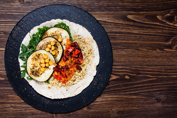 Groats with sauce and vegetables on tortilla