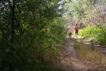 runner running across the field with his dog