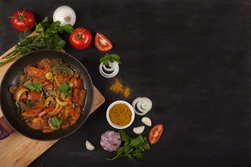 Process of cooking hot tomato sauce for pasta or spaghetti in a pan surrounded by the ingredients: onion, greens, radish, tomato, basil, bell pepper, paprika and red pepper in spoon on wooden table