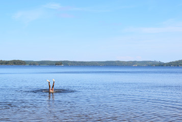 Fototapeta na wymiar Handstand in lake in Sweden