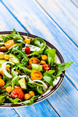 Greek salad with chickpea on wooden background