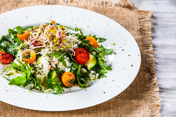 Salad with white rice on wooden background