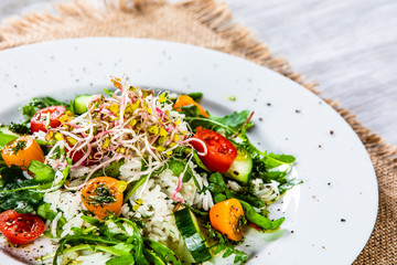 Salad with white rice on wooden background