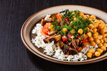 Rice with chickpea and vegetables on wooden table