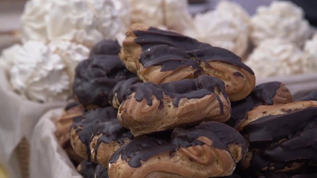 Bunch of ecler pastry covered with chocolate stacked on top of each other at the food market