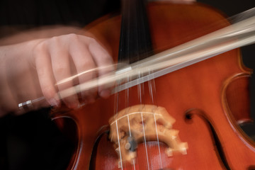 A young cellist practices intensely in this close up high resolution photo of strings, cello, and...