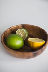 lime and lemon in a wooden plate