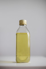  glass bottle with yellow liquid oil