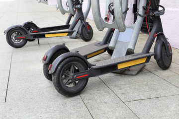 Electric scooters parked on a city street. Transport rental system, e-scooters on a sidewalk