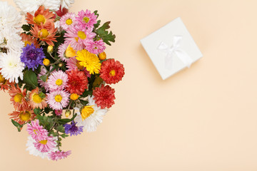 Top view of big bouquet of colorful different flowers and gift box..