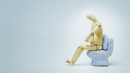 The gesture of a wooden puppet showing abdominal pain at the time of excretion