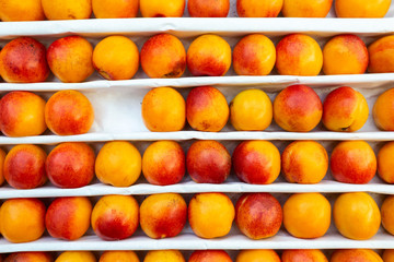A lot of peaches in box on sale at farms market