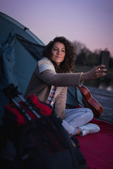 Fototapeta na wymiar Woman taking selfie while camping