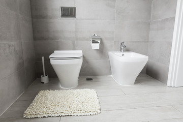 Fototapeta na wymiar White ceramic bidet and toilet at luxury bathroom