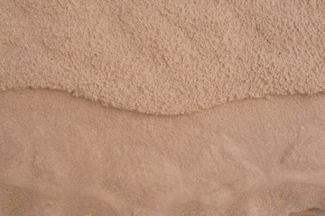 Fototapeta na wymiar Wet brown sand nature texture background