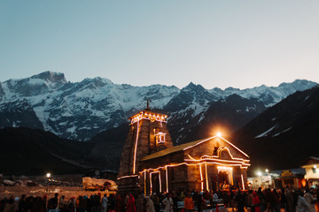 View of the Kedarnath temple lights at night with mountains in the background in Uttarakhand, India