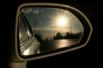 The view through the car's glass on the evening asphalt road with the hardened sun light