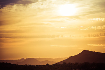 A sunset over a distant mountain in the Sonoran Desert of Arizona