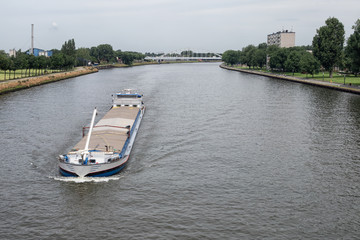 Ship at Dutch Amsterdam Rijn canal sailing near city Utrecht