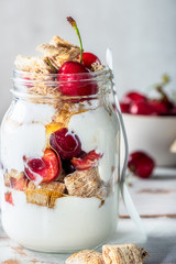 Bitesize shredded wheat with fresh cherry berries in Jar