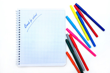 Back to school. Colorful markers and a notebook. A top flatly view of a white children's desk with colourful markers.
