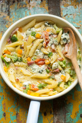 Pasta with vegetables and cheese sauce. Pasta with bacon, yellow peppers, broccoli, tomatoes and blue cheese 
