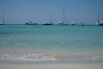Yachten und Katamaran im karibischen Meer am Horizont im klaren türkisen Wasser
