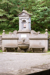 Naklejka premium Stone fountain in the woods