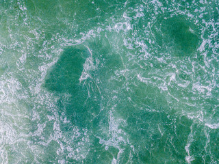 Overhead shot of turbulent water in river. Splashing water in aerial view with turquoise color.