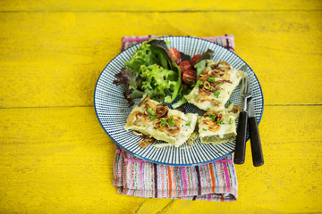 Maultaschen mit gerösteten Zwiebeln, Käse, Salat und Tomaten, Studio