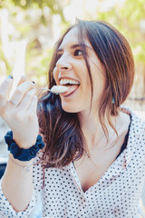 Beautiful young woman eating a piece of cake in the terrace in Madrid city