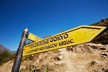 Wooden signpost in a mountain park, showing the way to Tengboche and Gokyo, a small Nepalese village with infrastructure for hikers.