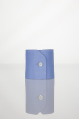 A blue cuff with a white button on the table