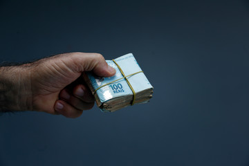 Hands holding Brazilian real notes - Money from Brazil - Notes of Real - Brazil BRL banknote