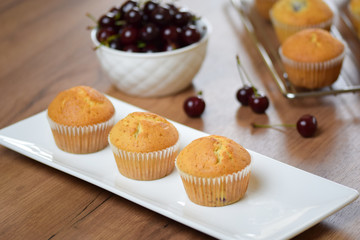 Muffins with cherry on a ceramic plate.