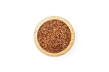 Lot of whole raw red quinoa seeds in a wooden bowl flatlay isolated on white background
