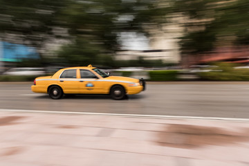 Fototapeta na wymiar Motion Blur of Taxi Speeding Down a City Street