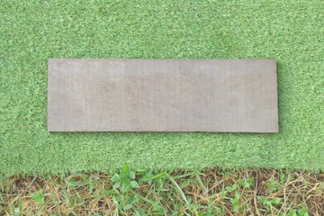 Old wooden plates placed on the grass background, green grassland, the same as the grass that does not fill the area.