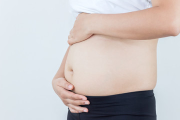 Happy pregnant woman holds hands on belly on a white background. Concept of first weeks pregnancy.