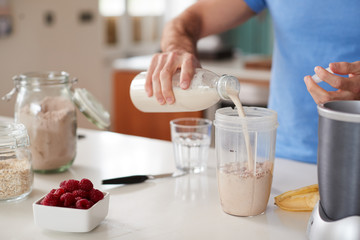 Close Up Of Man Making Protein Shake After Exercise At Home - obrazy, fototapety, plakaty