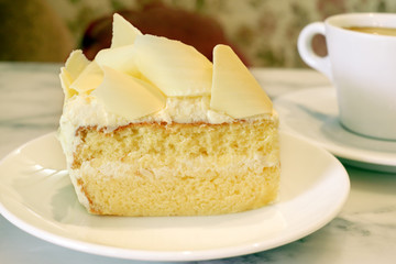 white chocolate cake with a cup of coffee on marble table top