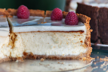 close-up of delicious homemade cheesecake with raspberries on blurred background