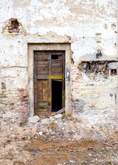 Fototapeta na wymiar Old and destroyed door of damaged building 