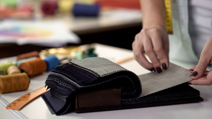 Seamstress reviewing fabric samples checking their quality before ordering