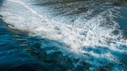 Close up of white, fast flowing, turbulent water flowing over dam on Ave River in Portugal 
