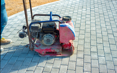 Vibrator with rubber plate for compacting paving with interlocking blocks