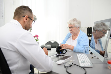 elderly senior woman having a medical consultation with her doctor in office diagnostic