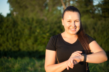 Pretty young woman using smart watch before her sport activity