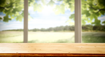 Table background with wooden top board with nice forest and gardens view in distance. Happy barbecue or picnic time with family. Empty space on the table top for an advertising product..