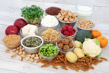 Vegan health food selection with tofu bean curd, fruit, vegetables, pasta, grains, sos mix, nuts, seeds, almond milk, butter and yoghurt. High in antioxidants, dietary fibre, omega 3 and vitamins.